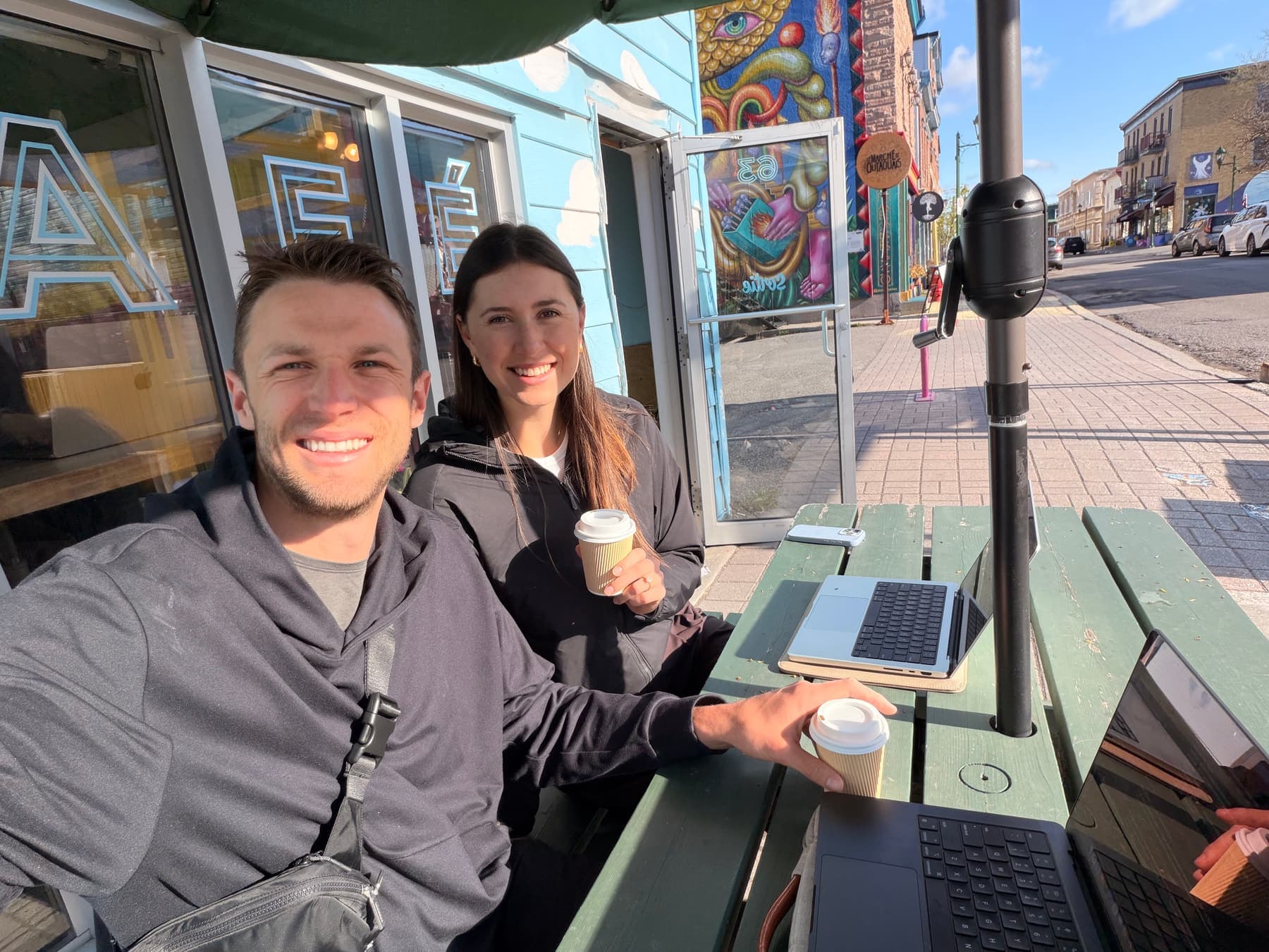 Jordan and Julia drinking coffee outside a cafe.